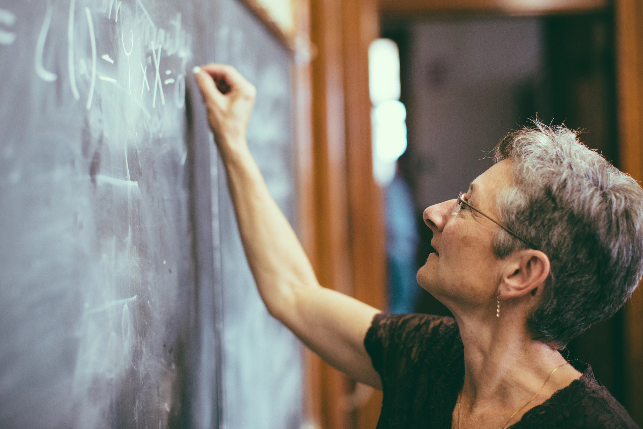 a teacher writing on a chalk board