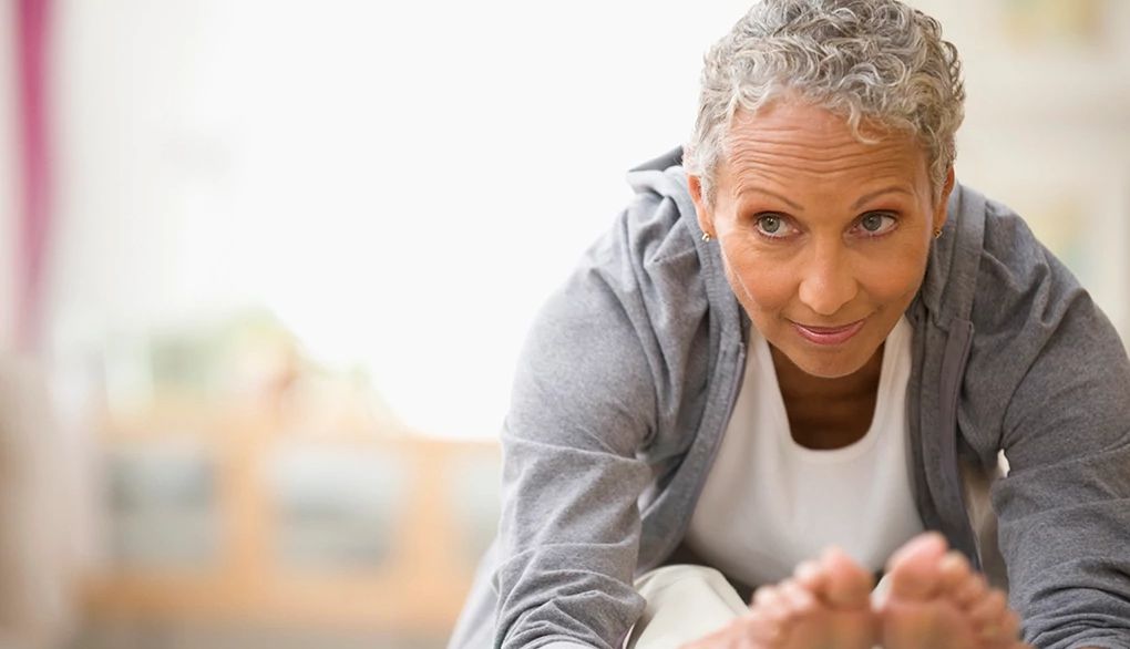 Yoga may affect brain structure A woman leaning forward to stretch her legs on a yoga mat