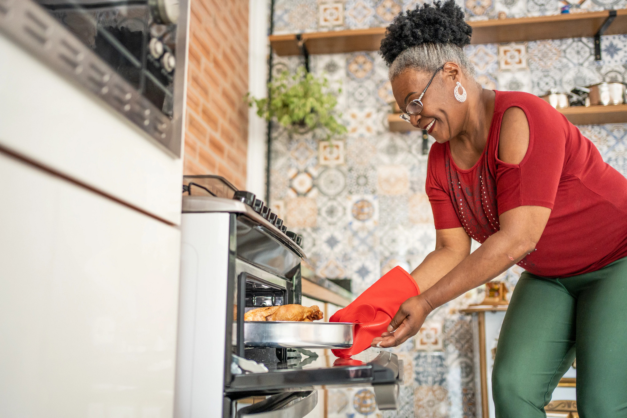 Woman taking a pan of food out of the oven