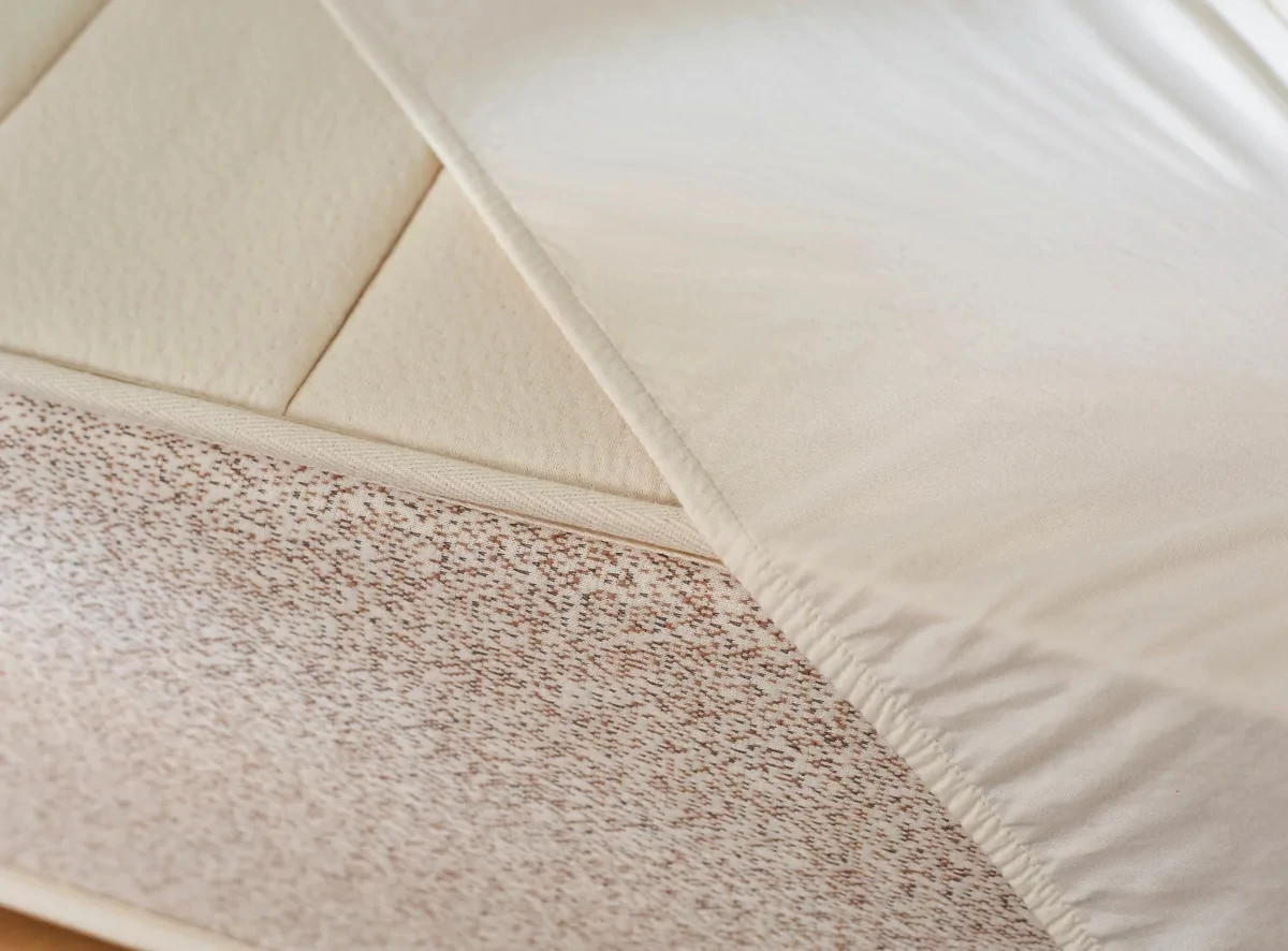 A close-up shot of the Birch Waterproof Mattress Protector partially on a mattress