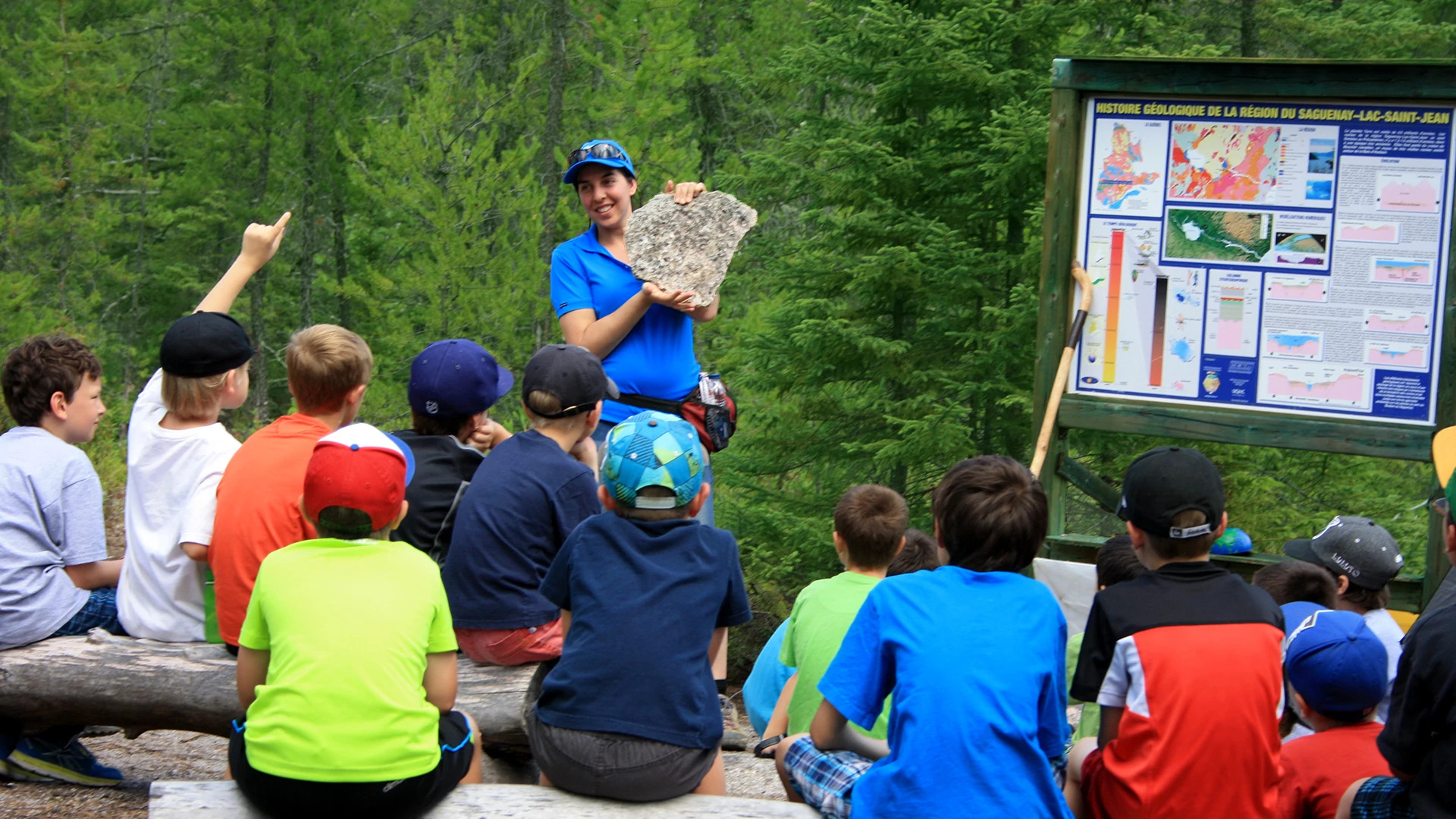 an instructor shows kids a fossil at Saguenay–Lac-Saint-Jean