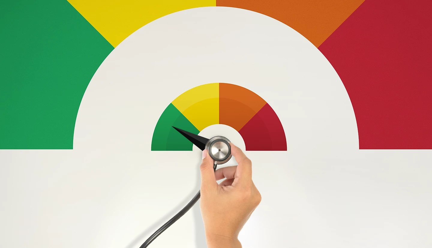a hand holding a stethoscope being turned like a dial with the colors green, yellow, orange and red 