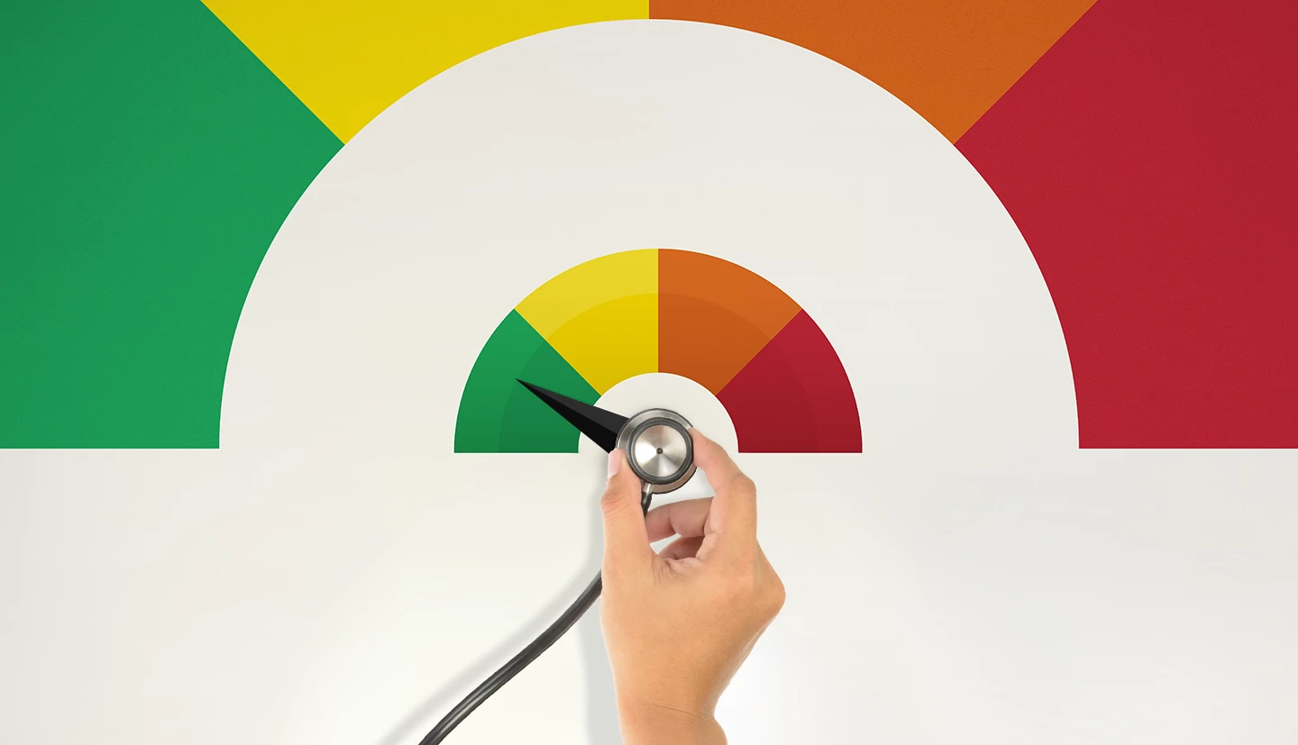 How, When and Why to Check (or Freeze) Your Credit a hand holding a stethoscope being turned like a dial with the colors green, yellow, orange and red
