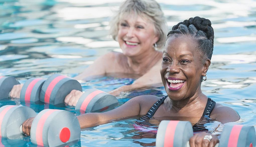 Aerobic exercise can benefit your brain in several ways Two smiling women doing water aerobics in a pool