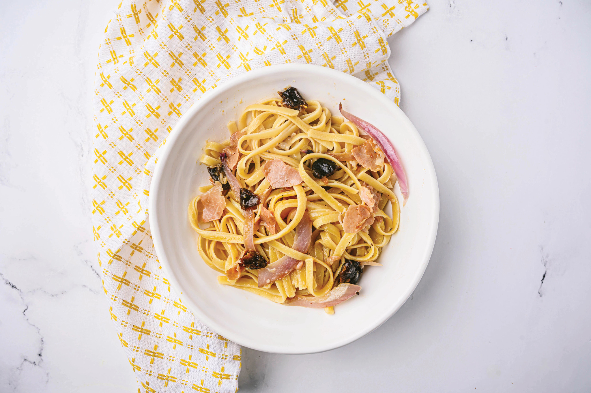 Fettuccine con prosciutto, ciruelas pasas y pimienta negra 