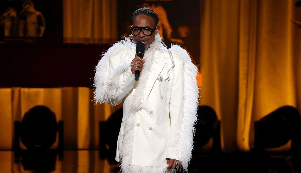 Billy Porter speaking into a microphone onstage at the Gershwin Prize concert honoring Elton John and Bernie Taupin