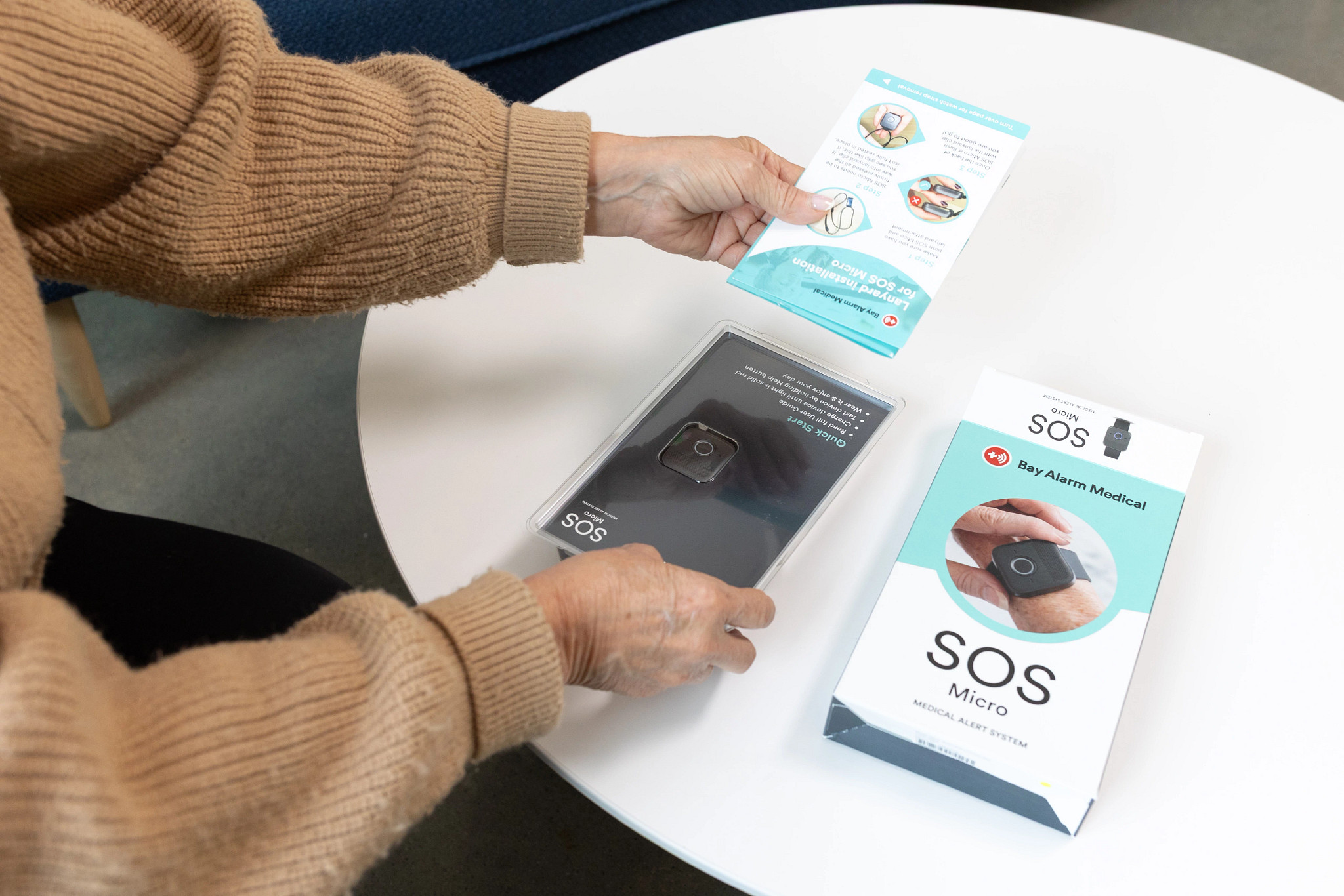 A woman taking the Bay Alarm Medical SOS Micro medical alert device out of the box.