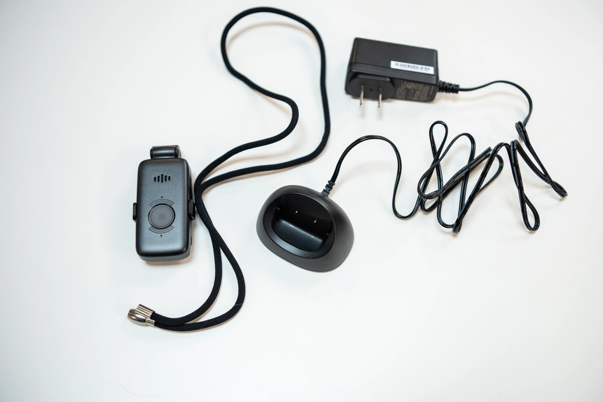 The Lifefone VIPx2 alongside its charging doc on a white table