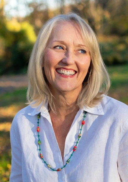 Amy Brecount White smiling in an outdoors photograph