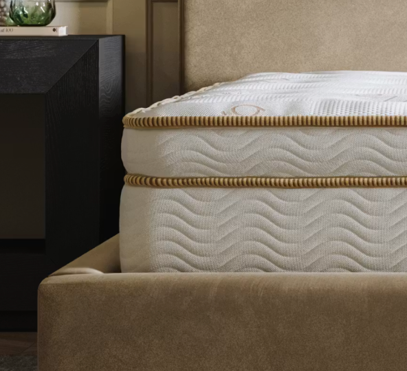 The Saatva Latex Hybrid in a beige velvet bed frame
