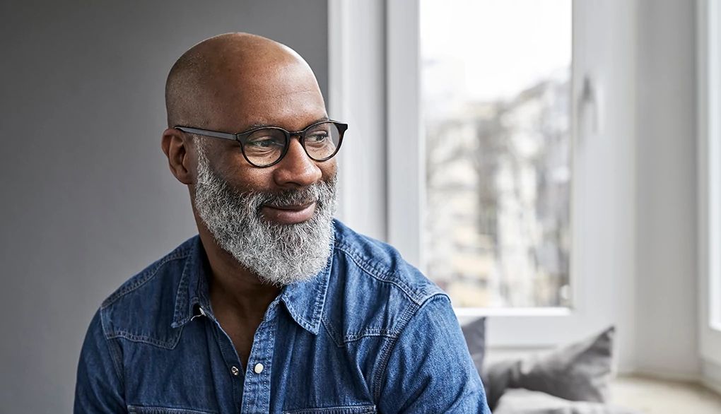 Your brain isn't "over the hill" in your 50s An up-close portrait shot of a man smiling inside a home