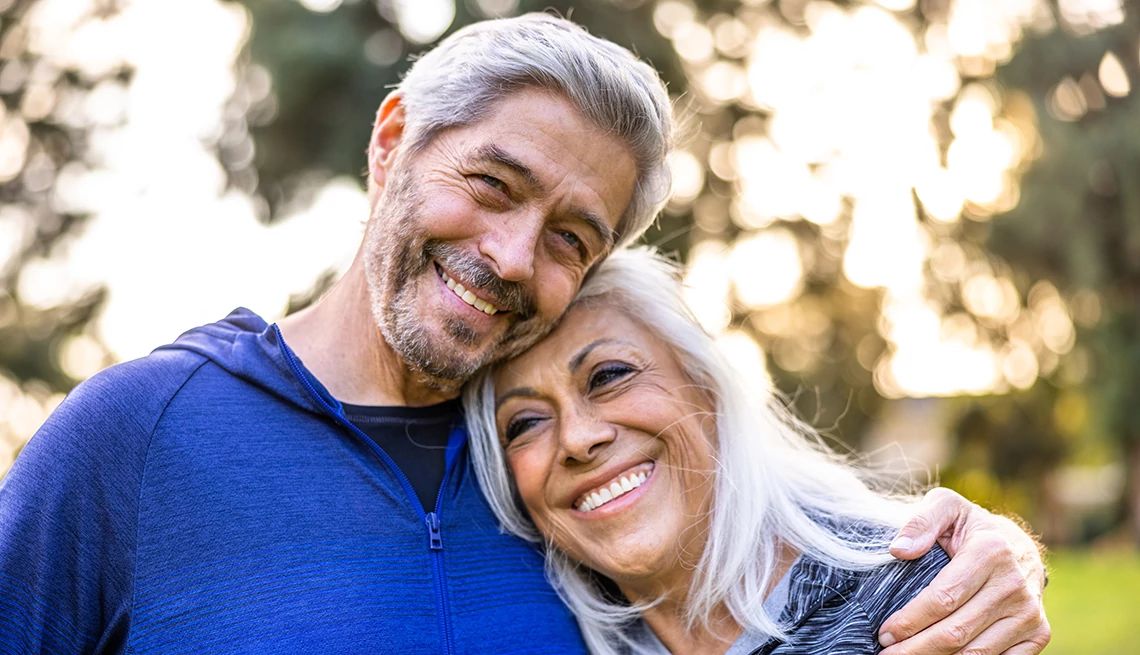 A happy brain is an important component of your well-being A man and woman couple smiling and side hugging outside