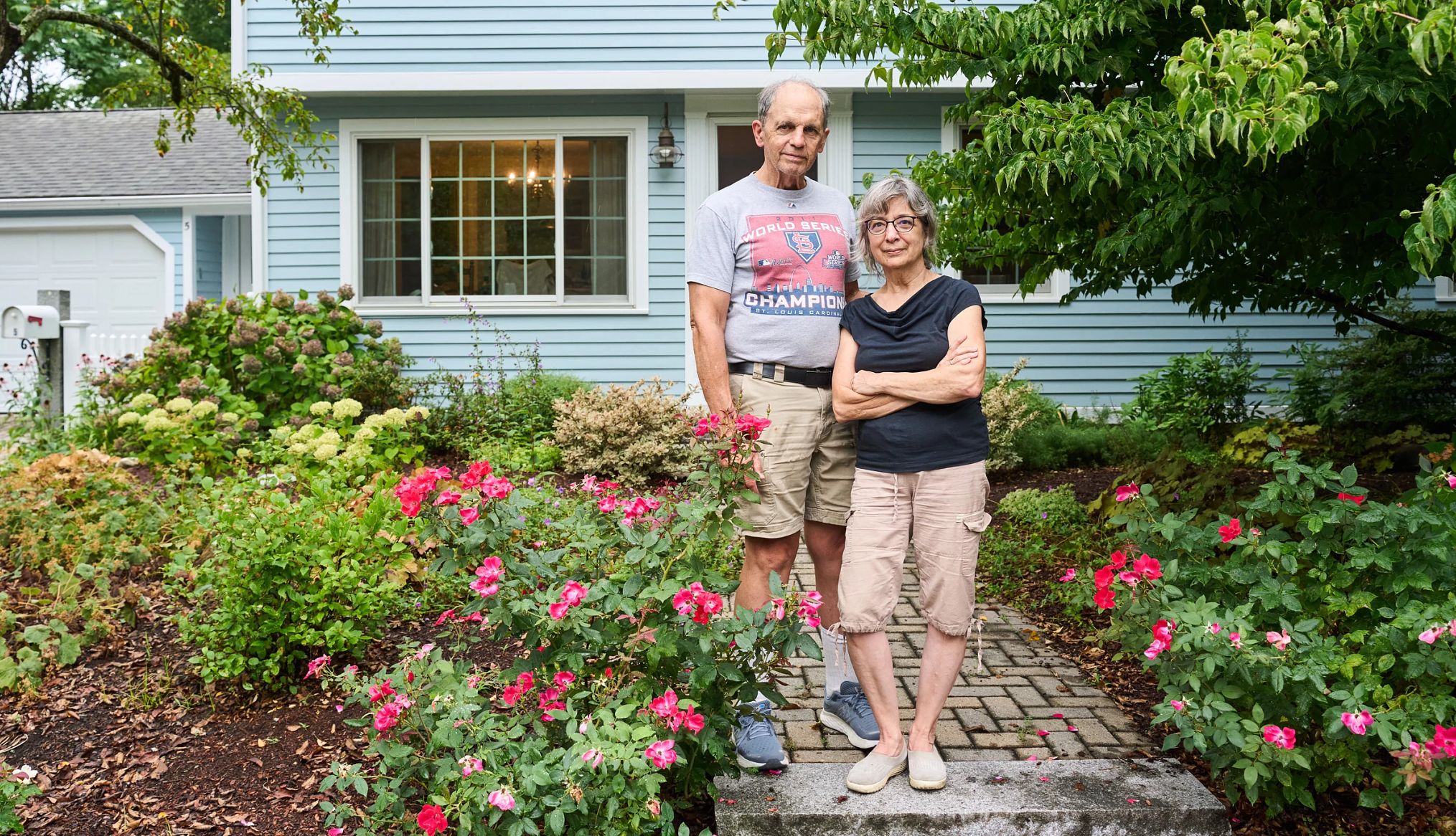 a couple standing in front of their house