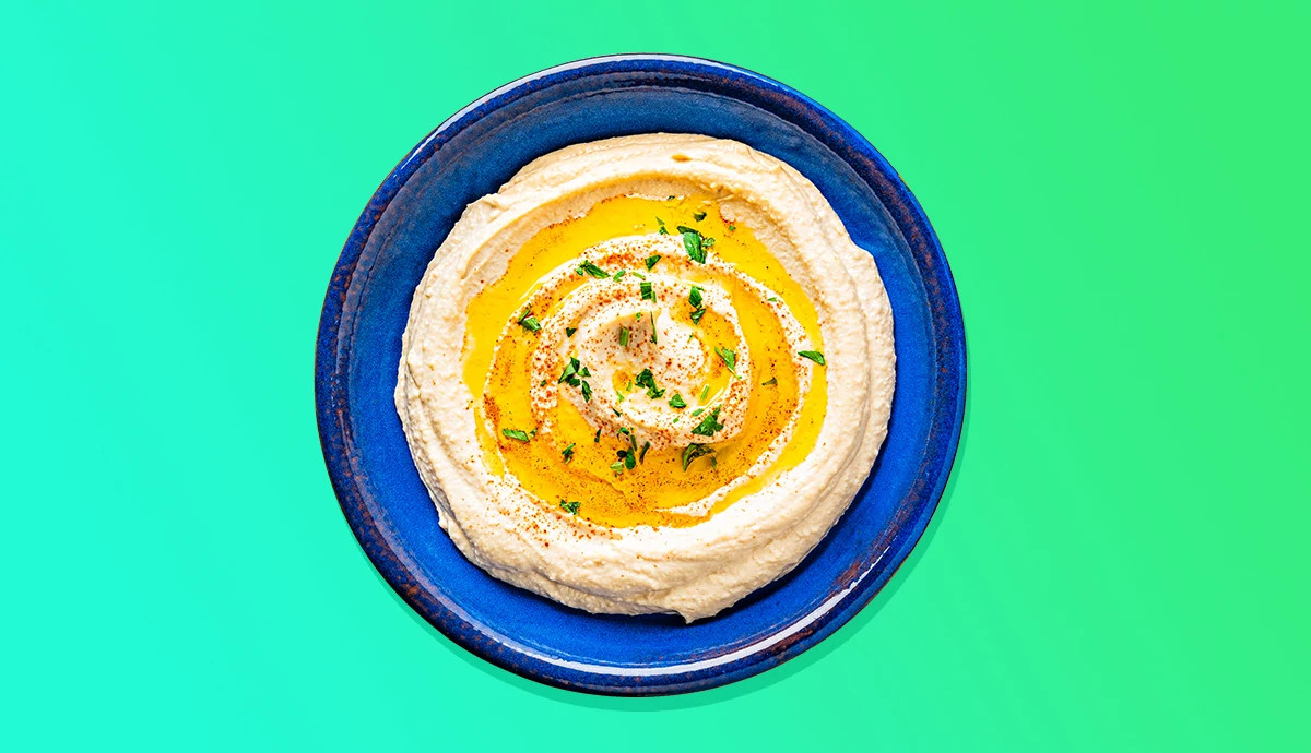 Bowl of creamy hummus drizzled with olive oil and spices.