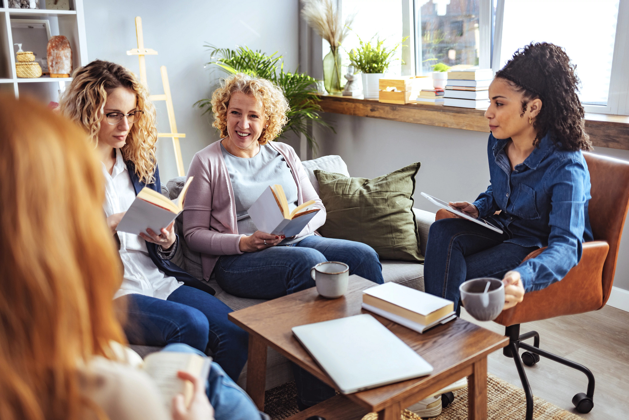Group Of Friends Taking Part In Book Club At Home