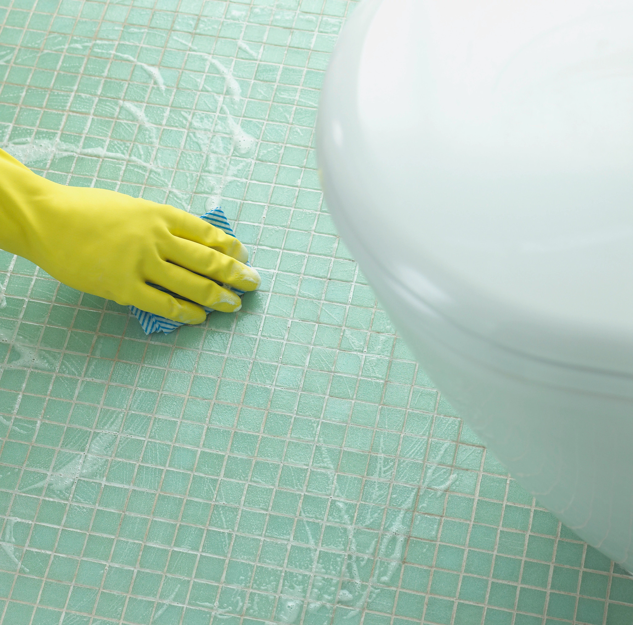 a hand cleaning a bathroom floor