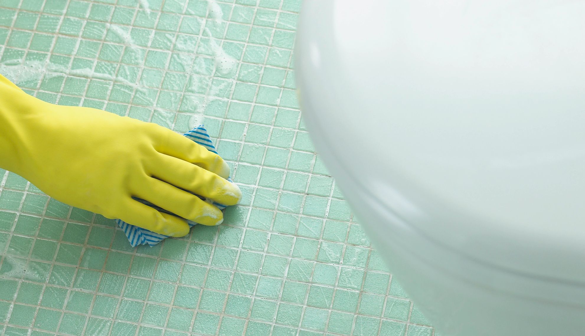 a hand cleaning a bathroom floor