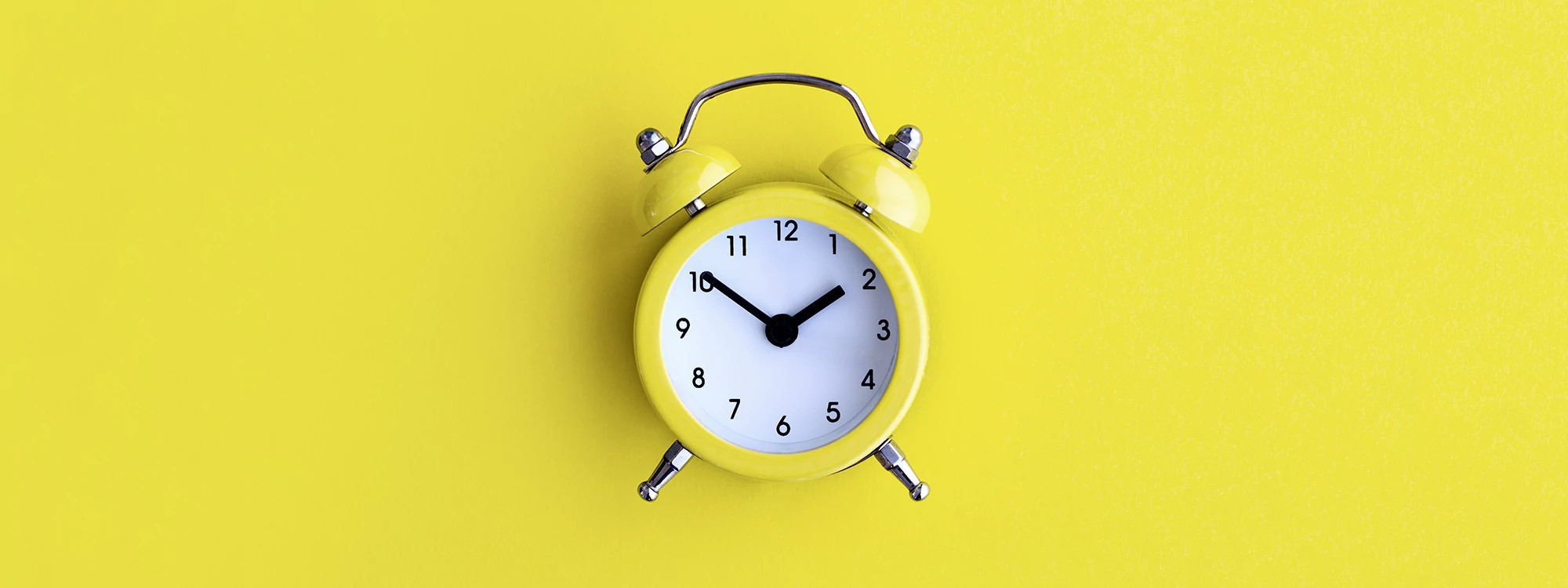 yellow alarm clock on a yellow background