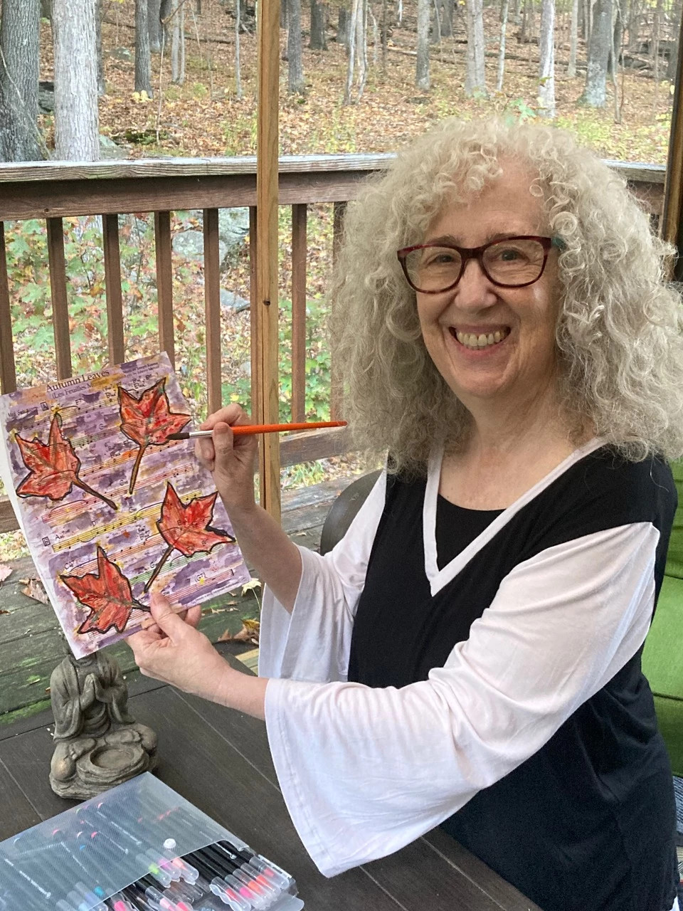 A photo shows Melinda Marks Burgard with one of her paintings