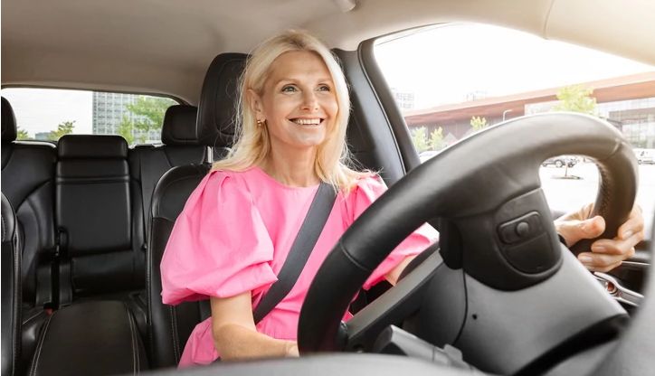 Woman driving a car and smiling Woman driving a car and smiling