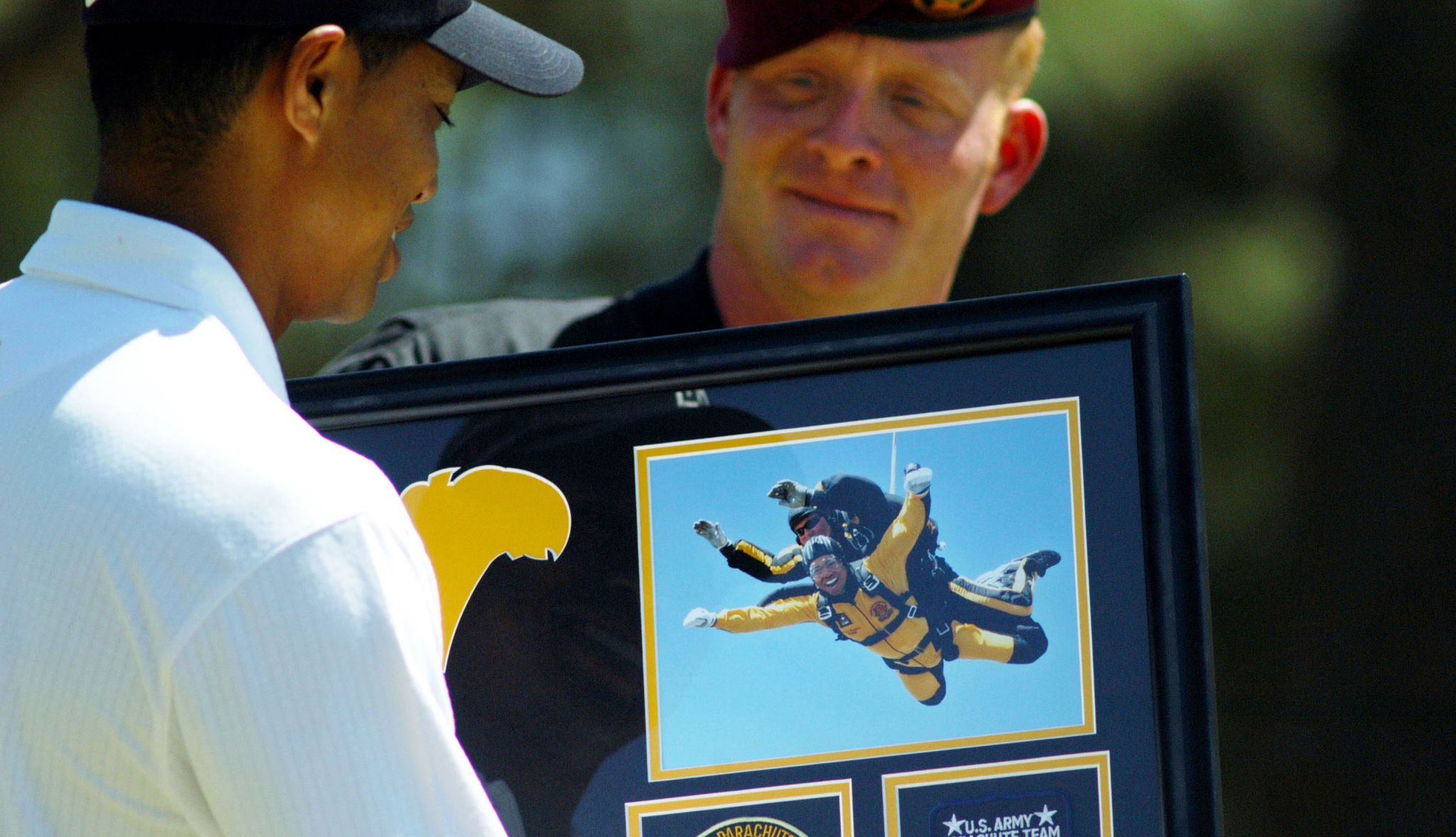 Tiger Woods jumps out of plane Someone handing a photo to Tiger Woods of him parachuting