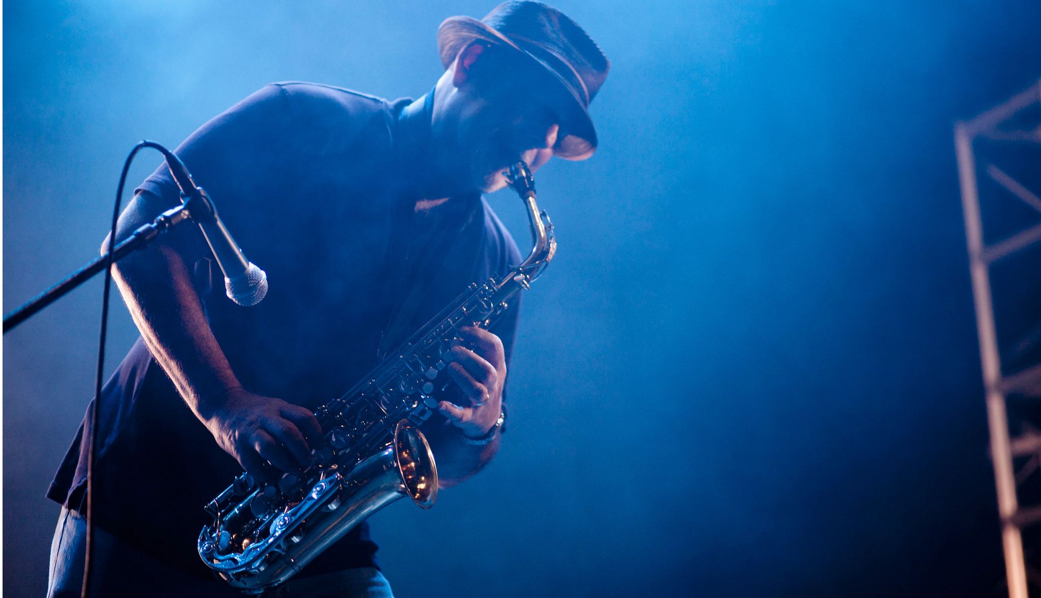 Black musician playing saxophone on stage Black musician playing saxophone on stage