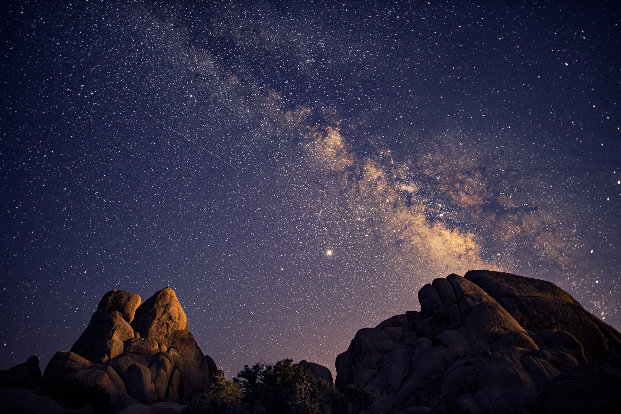 Rocks with the Milky Way Night Sky in the distance in Joshua Tree
