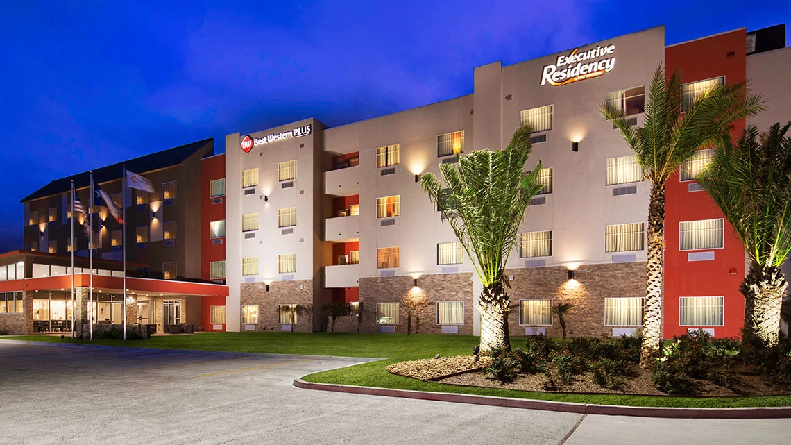 exterior of hotel at night, front entrance, parking lot