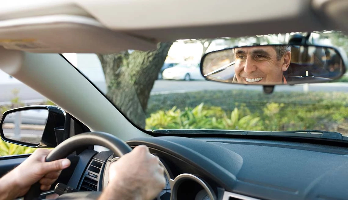 man looking through rear view window