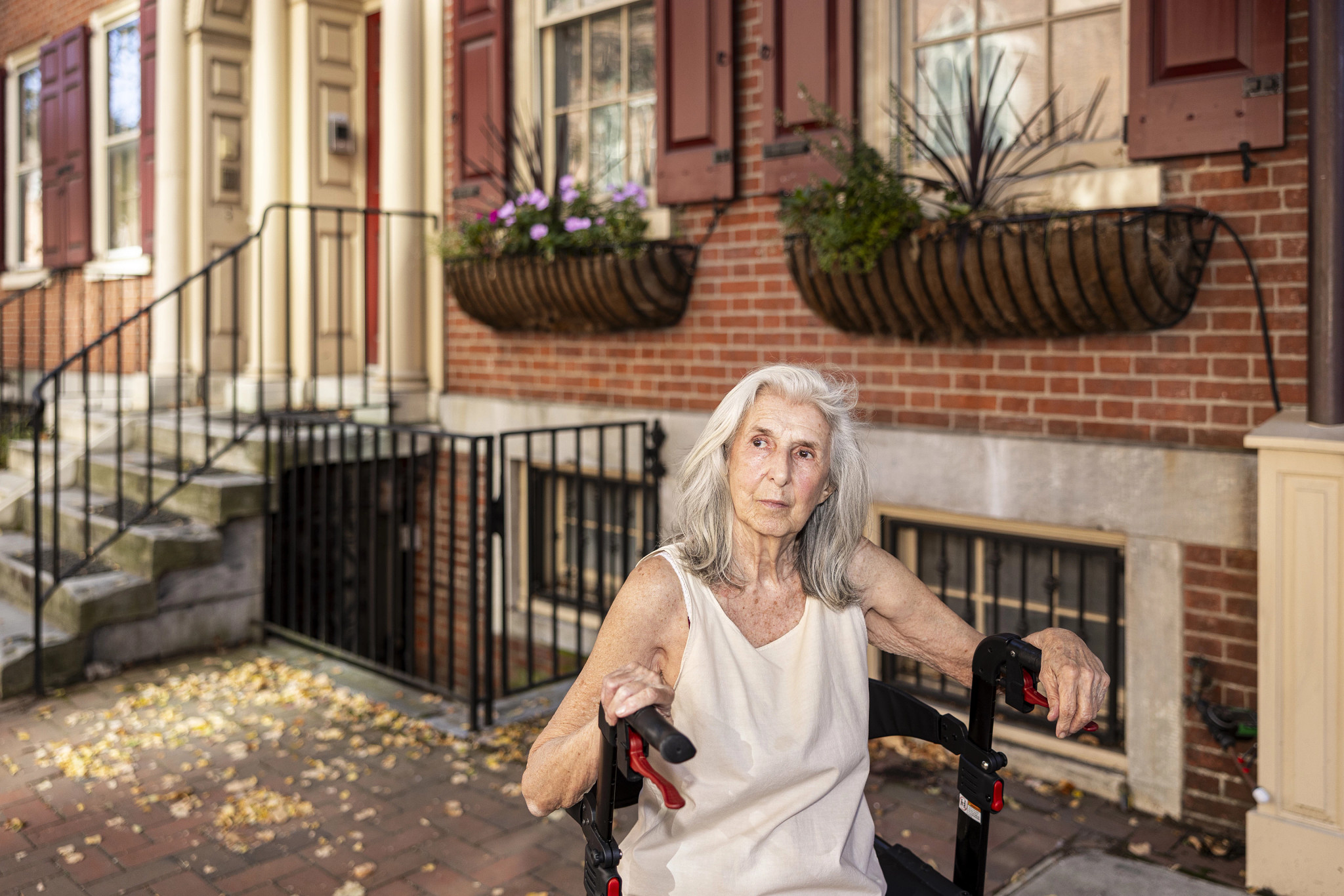 a woman looks into the distance in front of a brick building