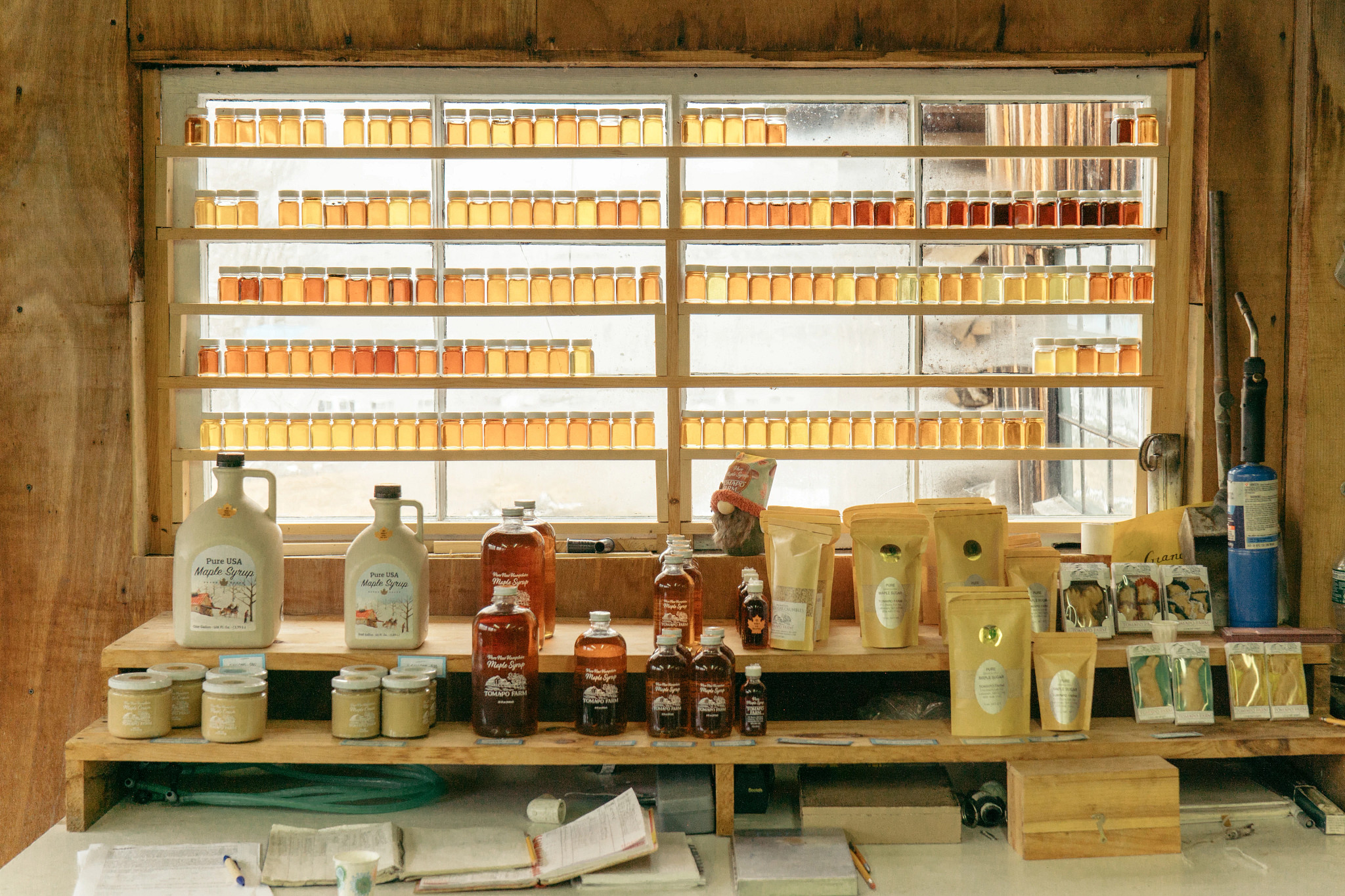a photo shows bottles containing maple syrup inside the sugar house at Tomapo Farm