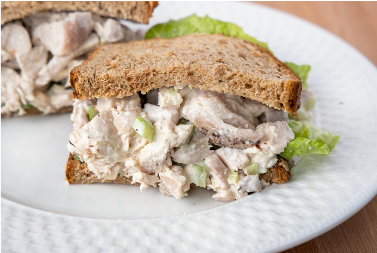 Chicken salad between two slices of bread on plate
