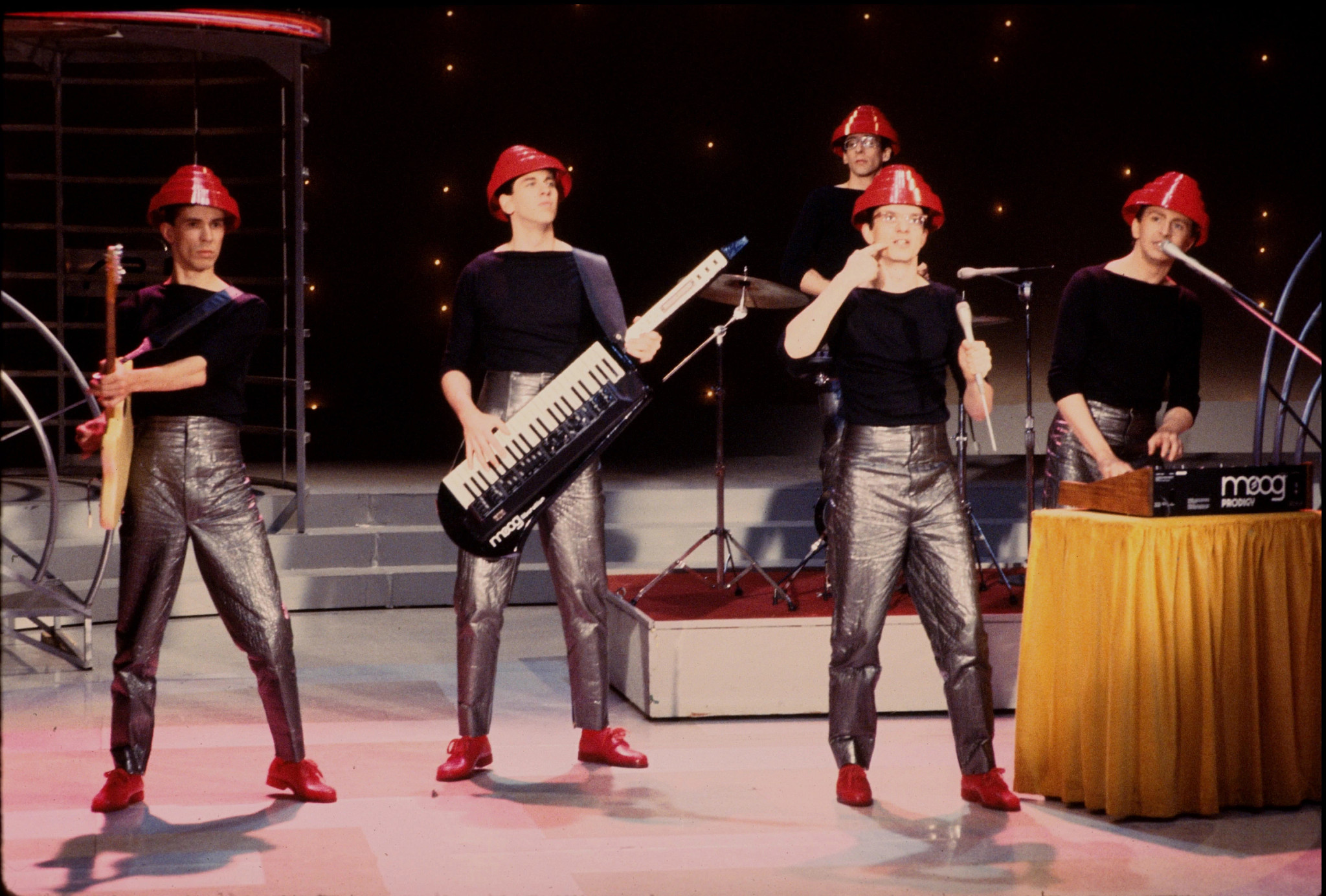 Devo performing in iconic red hats.