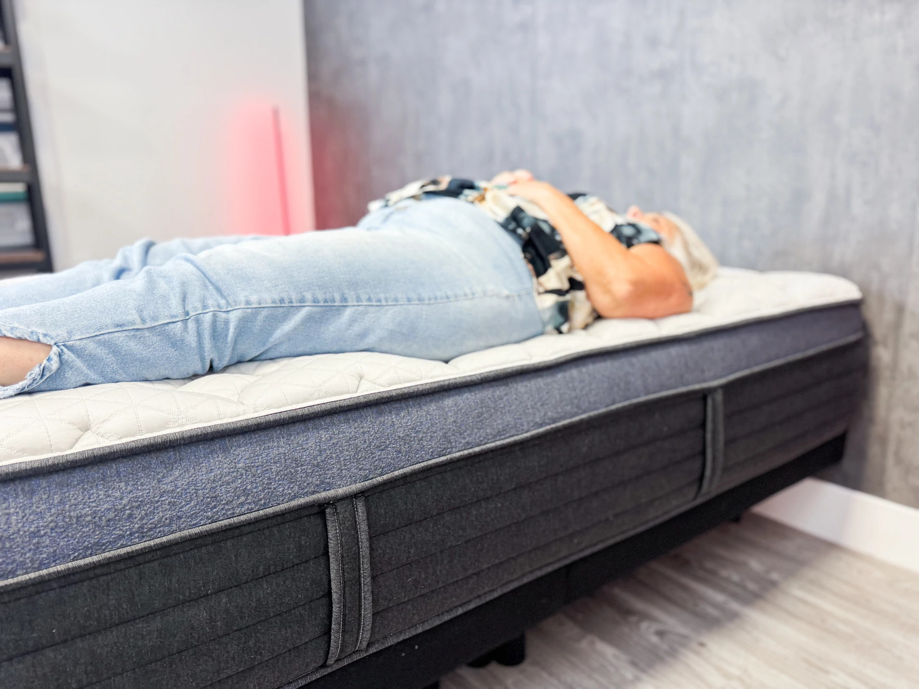 A woman lying on her back on the Helix Midnight Luxe
