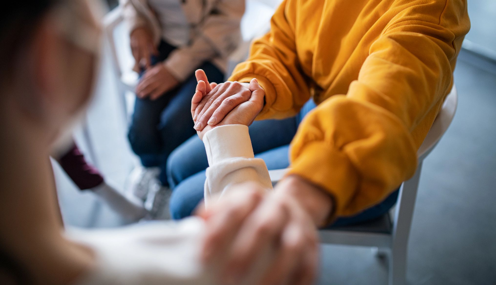Caregiver support groups can offer valuable help two people hold hands and comfort each other