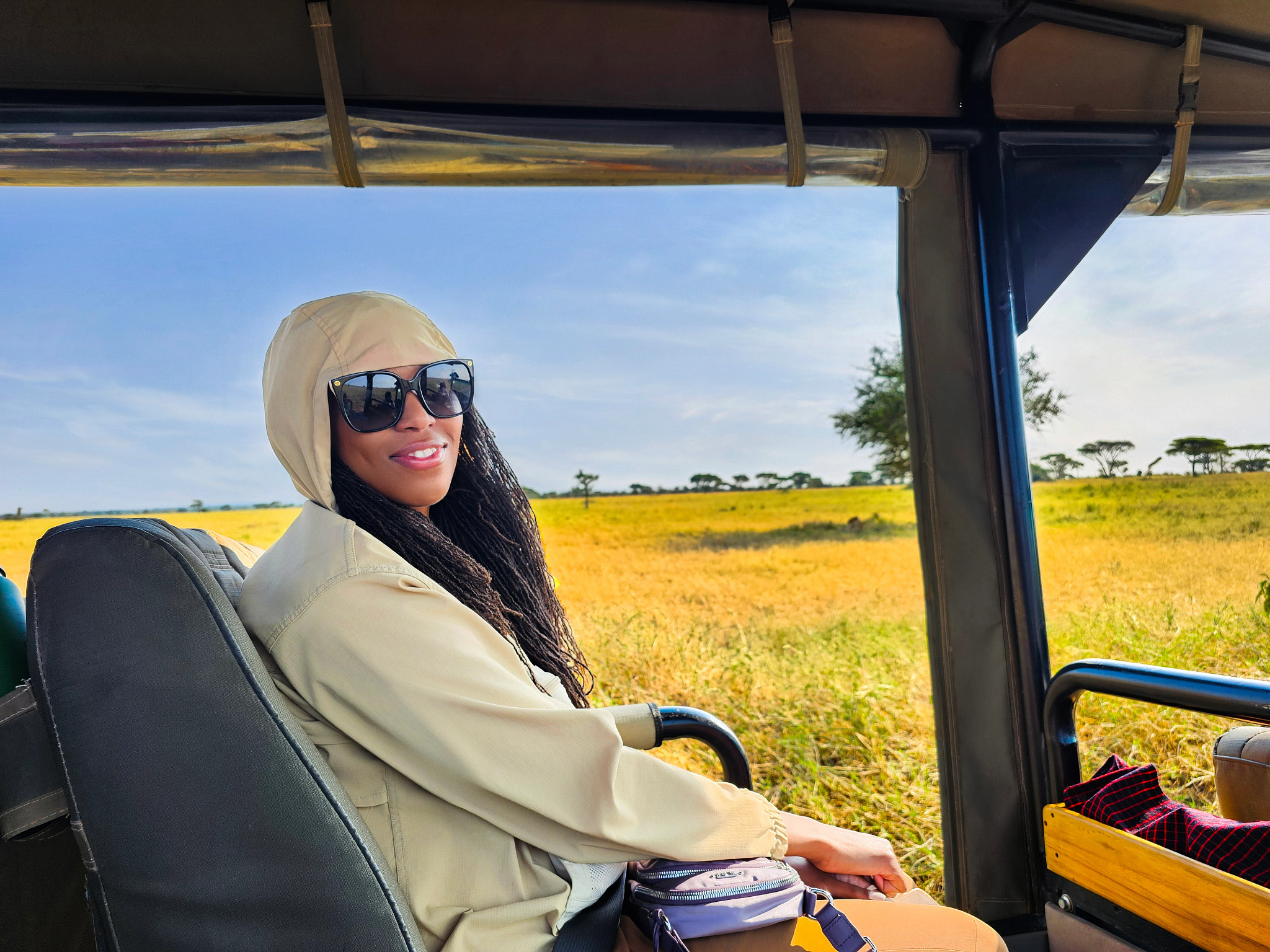 a woman poses for a picture while on a safari in the Serengeti