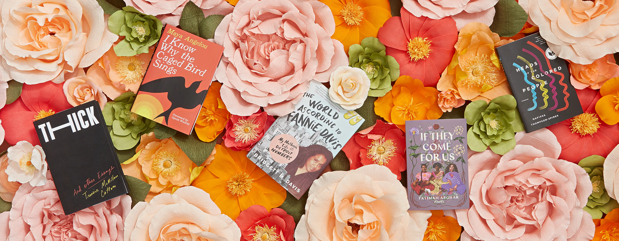 A picture of five books among spring flowers.