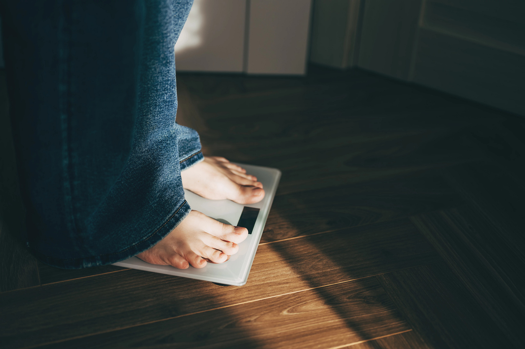 a view of a person's lower legs and feet, standing on a scale