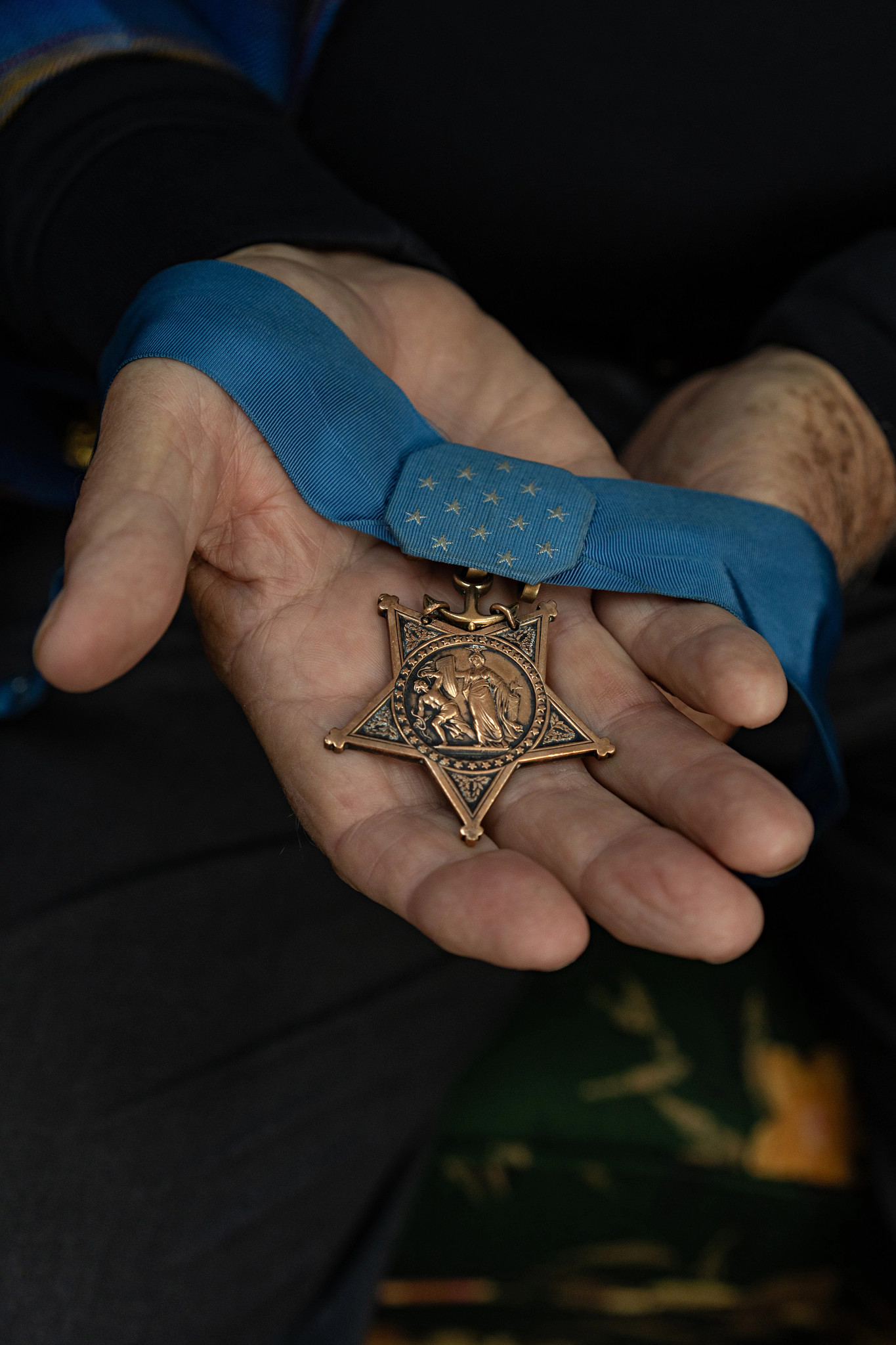 a hand holds the congressional medal of honor