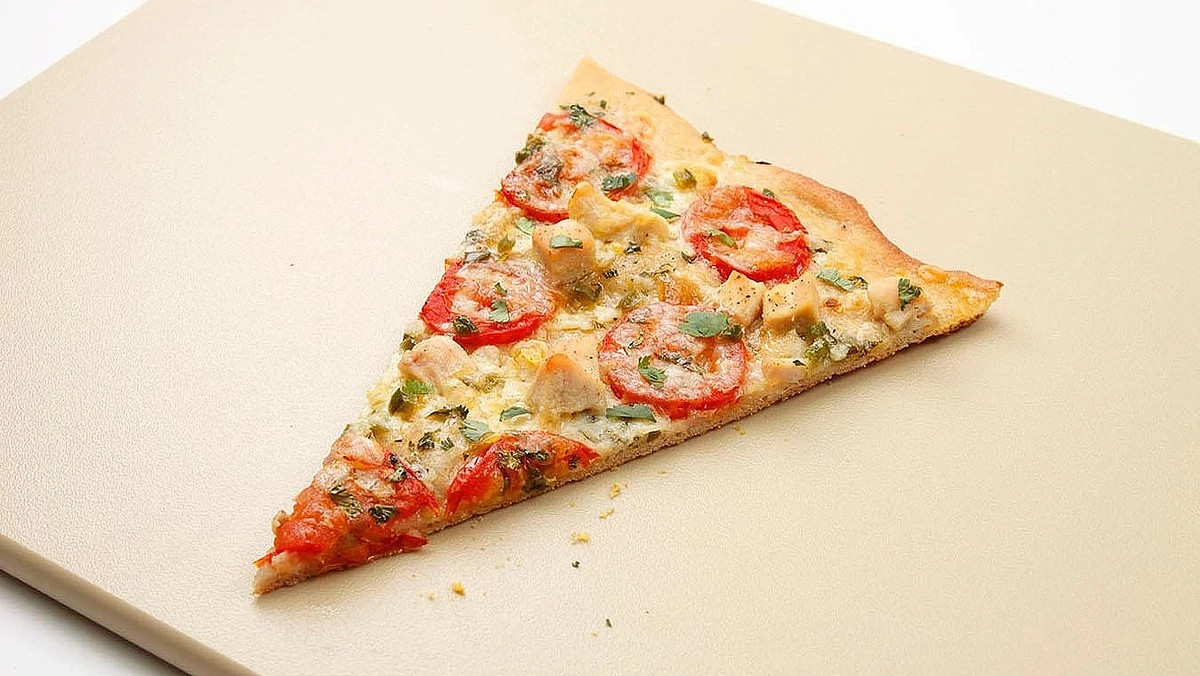 A close-up view of chicken, tomato and jalapeño pizza