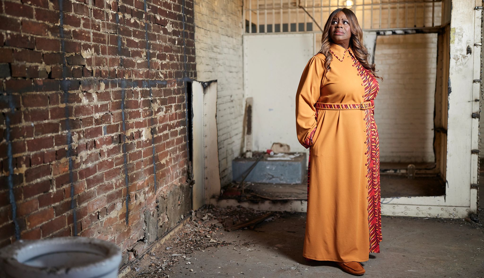 Retta hosts Scariest House in America Retta looking at brick wall of building; frightened look on her face
