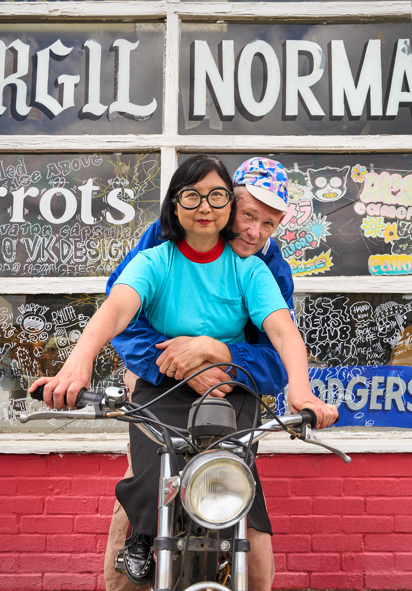 a photo shows Academy Award-nominated designer Shirley Kurata and artist partner Charlie Staunton on a moped outside their store Virgil Normal in Los Angeles