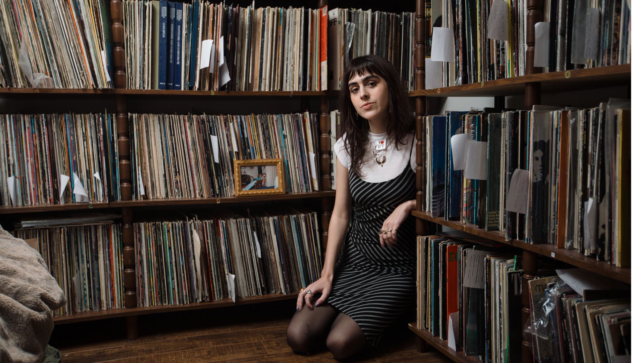My Dad Lives On, Through the Record Albums He Left Behind a woman sitting with thousands of records