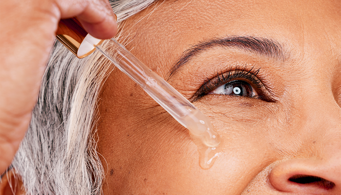 a person applying drops below their eye