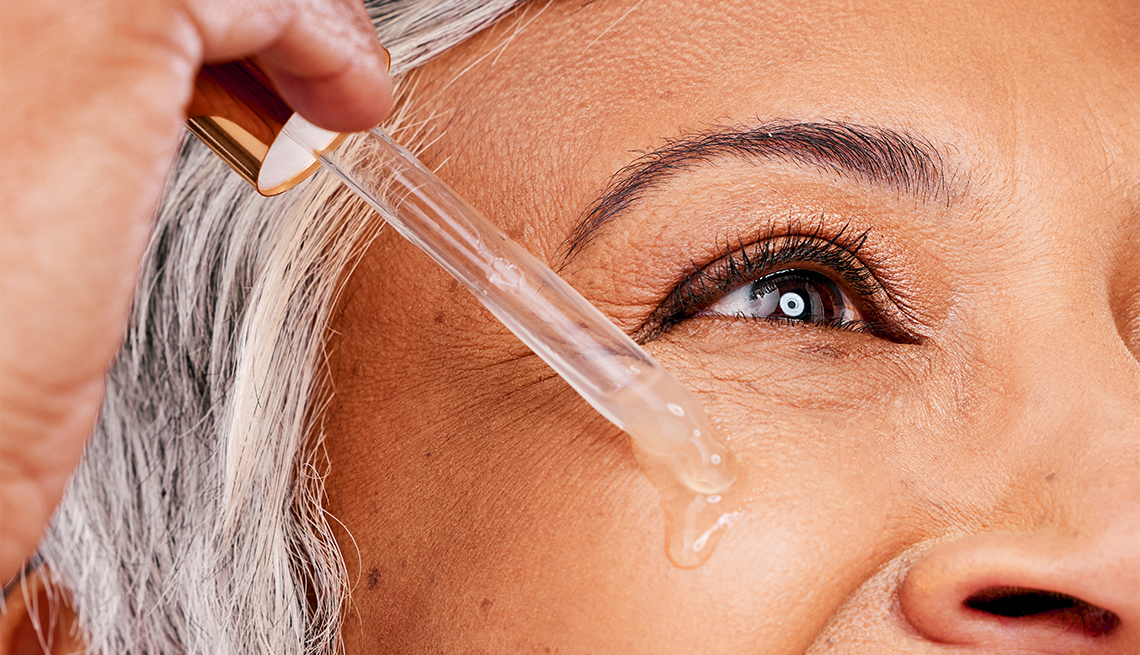 a person applying drops below their eye