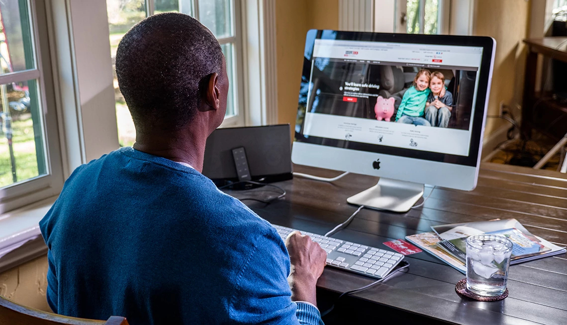 Un hombre afroamericano frente a su computadora Mac Un hombre afroamericano frente a su computadora Mac