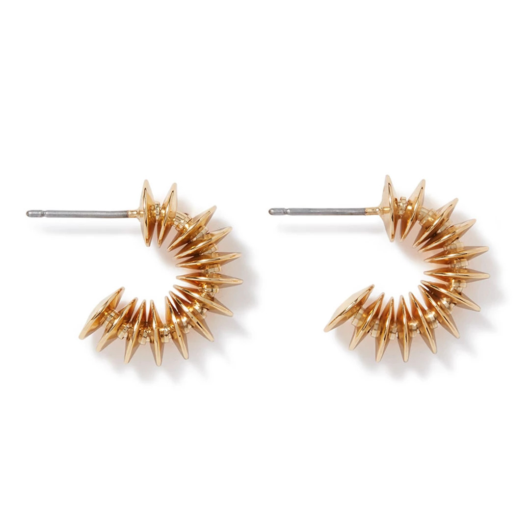 Gold disc huggie earring displayed against a neutral background