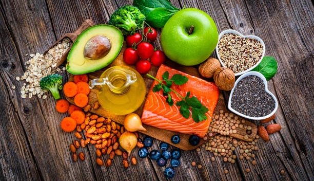 Best and Worst Foods for High Blood Pressure heart healthy foods from salmon to apples on and around a wooden serving tray