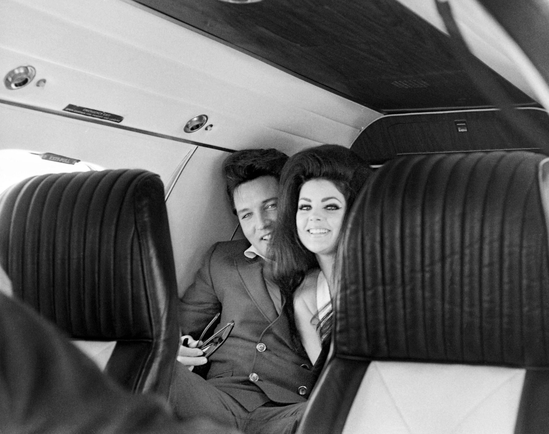 Priscilla Presley’s New Memoir elvis and priscilla presley smiling in the cabin of an airplane