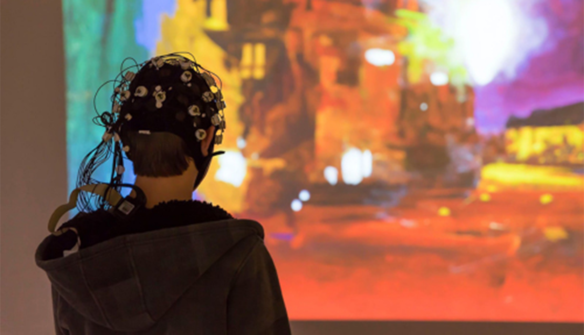 The Neuroarts Resource Center is an online platform designed to unite diverse fields, people, and organizations within the neuroarts community Electrodes connected to the head of a person looking at art